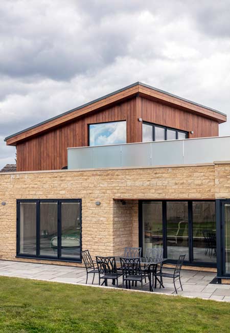 new build with cotswold stone and cedar cladding